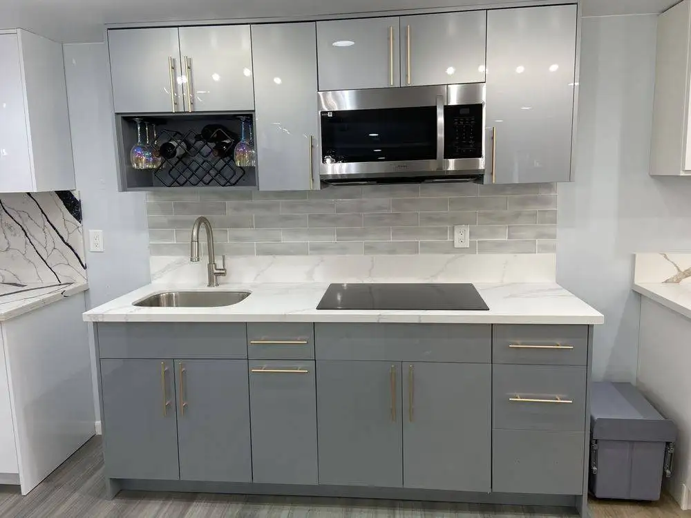 Grey high-gloss cabinets with quartz counter and tile backsplash on showroom display